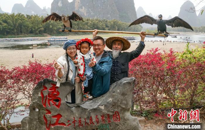 图为3月13日，游客与渔民模特在“20元人民币背景图”打卡处合影。　蒋丰慧 摄