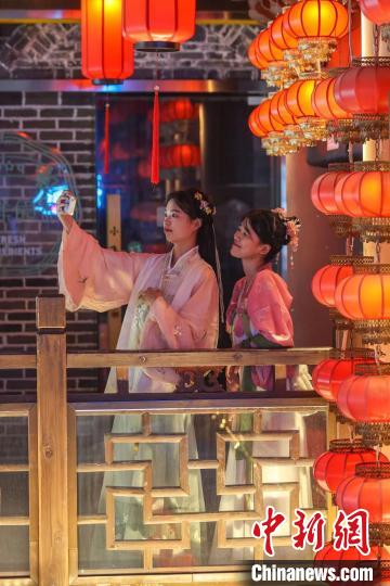 图为4月15日，江西南昌万寿宫历史文化街区，灯火璀璨人潮涌动，不少游客在参观游览。　刘力鑫 　摄